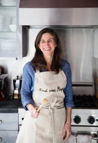 Leslie Jonath smiling in an apron in her kitchen